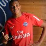 Kylian Mbappe berpose di depan lecana PSG