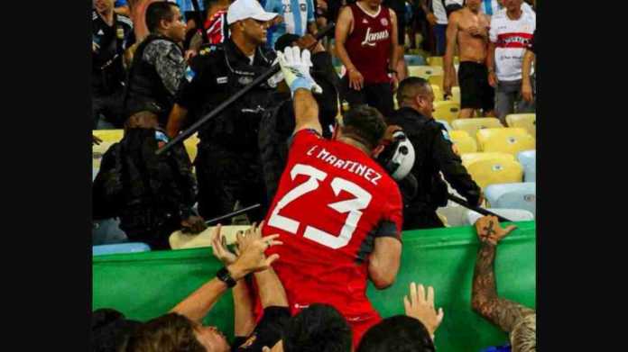 Kiper Emiliano Martinez menahan seorang polisi Brasil yang hendak memukuli fans Argentina