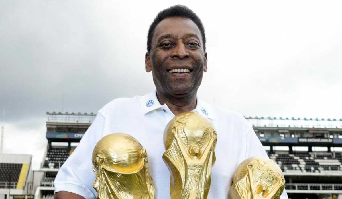 Pele bersama tiga trofi Piala Dunia