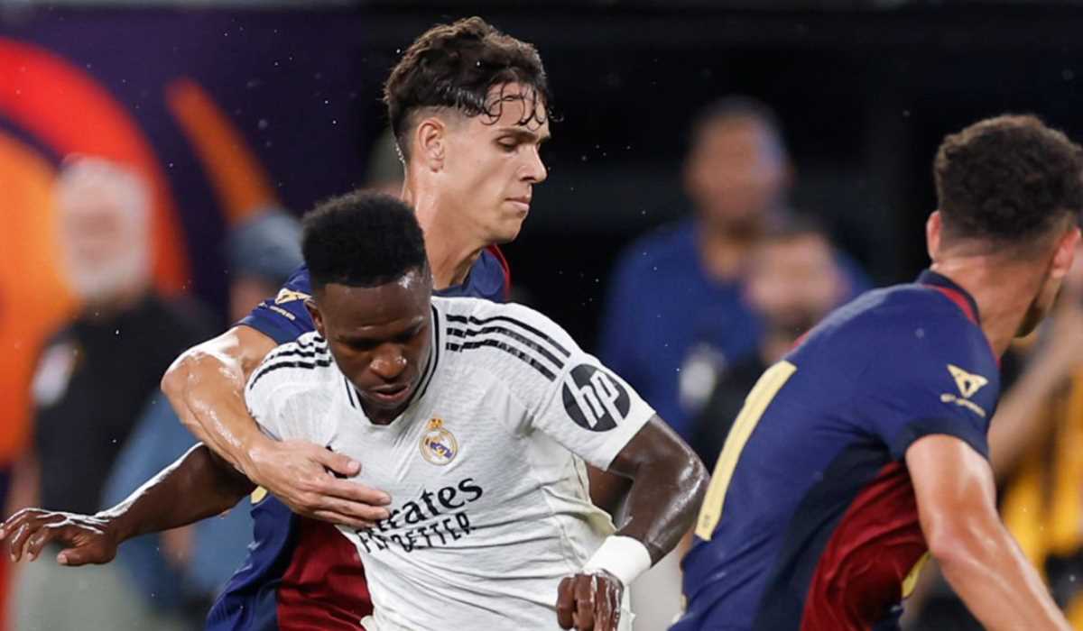 Vinicius Junior berduel dengan dua pemain Barcelona