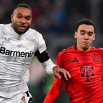 Jonathan Tah berebut bola dengan Jamal Musiala