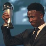 Vinicius Junior mengangkat piala pemain terbaik FIFA