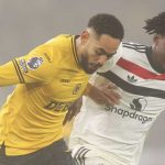 Matheus Cunha berduel dengan Kobbie Mainoo di laga Manchester United vs Wolves