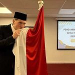 Ole Romeny mencium bendera Indonesia dalam sumpah setia WNI