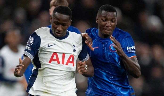 Pape Matar Sarr dari Tottenham berebut bola dengan Moises Caicedo dari Chelsea