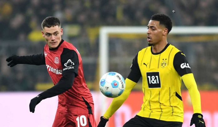 Felix Nmecha berebut bola dengan Florian Wirtz di laga Borussia Dortmund vs Bayer 04 Leverkusen