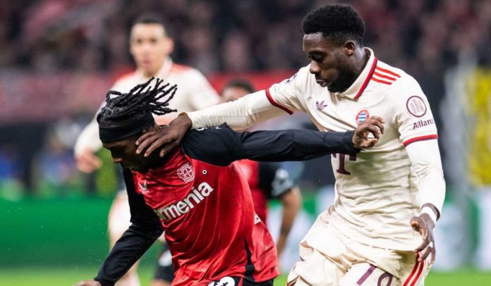 Jeremie Frimpong menjaga bola dari Alphonso Davies di laga Bayer Leverkusen v Bayern Munchen