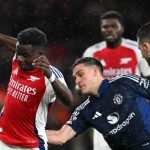 Manuel Ugarte berusaha menghentikan Bukayo Saka di laga Arsenal v Manchester United
