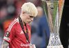Alejandro Garnacho berjalan tertunduk melewati trofi Liga Europa