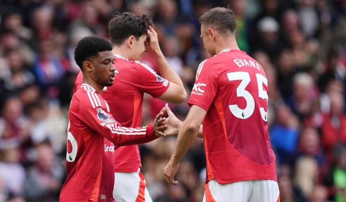 Amad Diallo menjabat tangan Jonny Evans usai mencetak gol