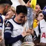 Son Heung-Min memeluk trofi Liga Europa disaksikan rekan-rekannya