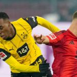 Jamie Gittens melewati Joshua Kimmich di laga Borussia Dortmund v FC Bayern Munchen