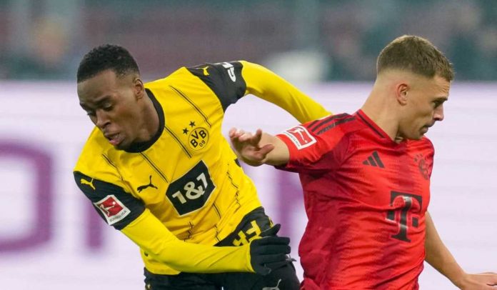 Jamie Gittens melewati Joshua Kimmich di laga Borussia Dortmund v FC Bayern Munchen