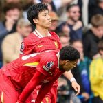 Jarrel Quansaha menunduk dengan bersandar lutut di samping Wataru Endo