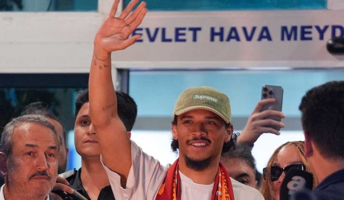 Leroy Sane melambaikan tangan ke arah fans Galatasaray setibanya di Turki