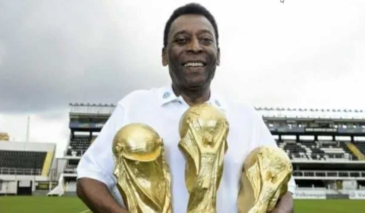 Pele memamerkan tiga trofi Piala Dunia