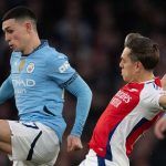 Phil Foden mempertahankan bola dari usaha Leandro Trossard
