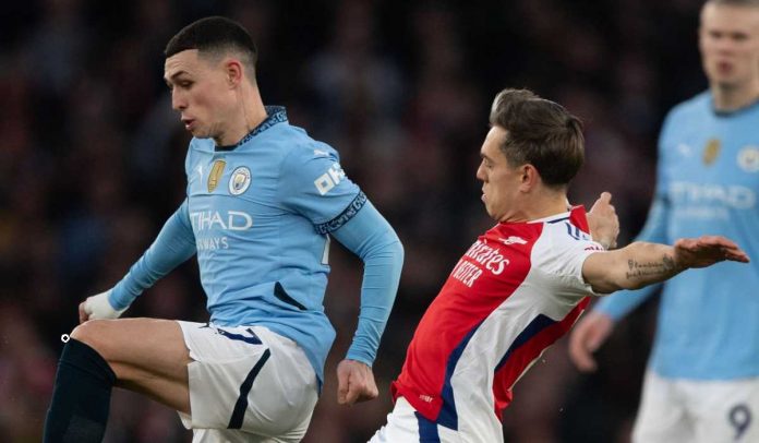 Phil Foden mempertahankan bola dari usaha Leandro Trossard