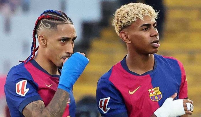 Raphinha dan Lamine Yamal berdiri bersama di pertandingan Barcelona