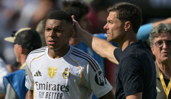 Xabi Alonso memegang kepala Kylian Mbappe selama laga PSG vs Real Madrid