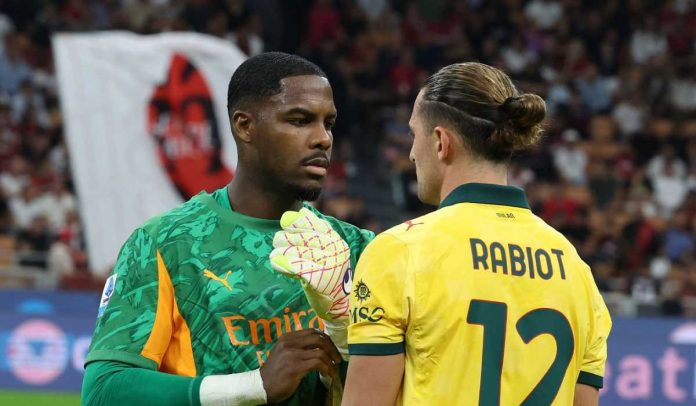 Mike Maignan berbicara dengan Adrien Rabiot selama laga AC Milan vs Bologna