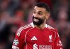 Mohamed Salah tersenyum selama laga Liverpool vs Atletico Madrid