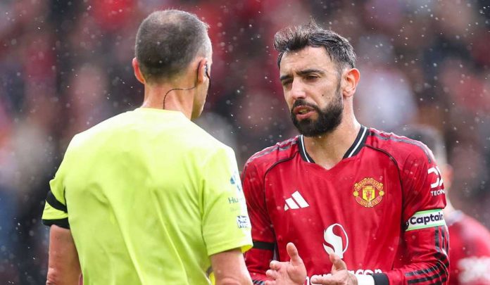 Stuart Attwell sedang berbicara dengan Bruno Fernandes