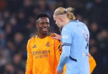 Vinicius Junior sedang berbicara dengan Erling Haaland
