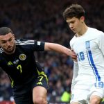 Konstantinos Karetsas berebut bola dengan John McGinn