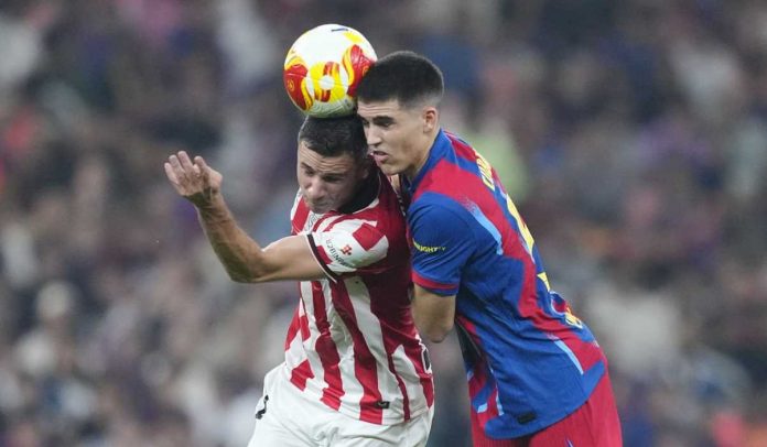 Pau Cubarsi berduel udara dengan Inigo Ruiz di laga Barcelona vs Athletic Bilbao